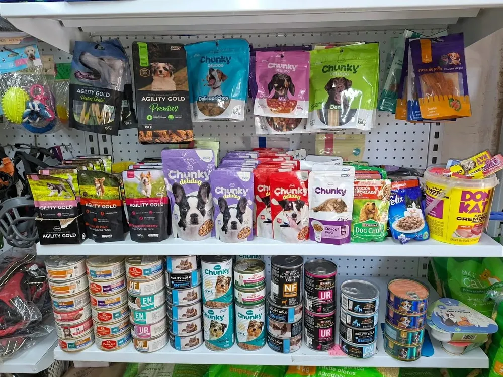 Estantería de Patitas Pet Shop con snacks y premios para perros y gatos: Chunky, Agility Gold, Dog Chow, Don Kat y latas húmedas de distintas marcas